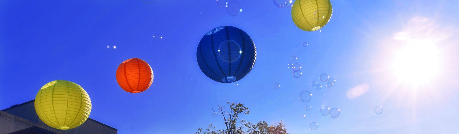 colorful paper lanterns and bubles against a blue sky